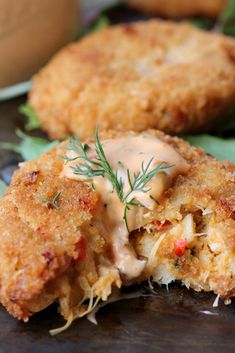 two fried food items on a plate with sauce