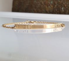 "Dainty and elegant 14 kt gold-filled name and date bracelet. So slim, yet shines and glistens with your every move. 14k gold fill bar dimensions: 45 mm x 3.5 mm 14kt gold fill chain and spring ring clasp Please make sure to indicate the name and date desired to be engraved. Simply leave me a message in the \"note to seller\" field upon checking out. The letters will be in upper case. I can engrave initials as well. Bracelet Sizing I recommend measuring your wrist's circumference and adding 1/4 Bar Bracelet Personalized, Personalized Gold Bracelet, Lingot D'or, Mom Jewelry Personalized, Date Bracelet, Nameplate Bracelet, Custom Engraved Bracelet, Roman Numeral Bracelet, Gold Bar Bracelet