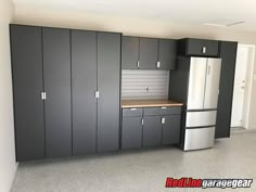 an empty kitchen with black cabinets and white refrigerator freezer next to the counter top