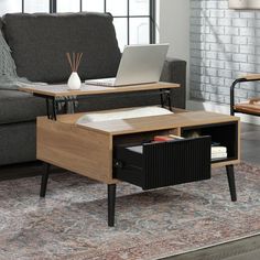 a living room with a couch, coffee table and laptop