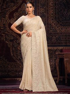 Elevate your ethnic wardrobe with our lovely off-white sequins georgette traditional saree with blouse, a stunning ensemble perfect for weddings, festivals, parties, and special occasions.
Crafted in vibrant off-white color, this saree is adorned with intricate sequin work, thread work, and zarkan work, adding a touch of elegance and sophistication to your look.
The off-white georgette saree comes with a 5.50-meter length, allowing you to drape it in various styles to suit your preference. The u White Georgette Saree, Designer Sarees Wedding, Net Blouses, Latest Designer Sarees, Lehenga Style, Silk Saree Blouse, Designer Sarees Online, Bridal Sarees, Casual Saree