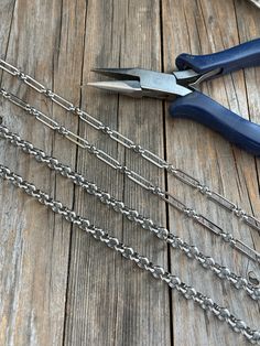 a pair of pliers and chains on a wooden table