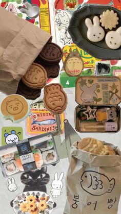 an assortment of cookies and cookie cutters are on the table next to a paper bag