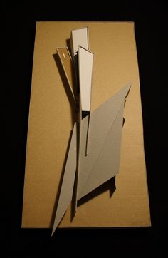 an origami bird sitting on top of a piece of cardboard with its wings folded