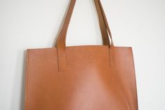 Made from vegetable-tanned leather from a family-run tannery in Santa Croce, Italy. These bags are handmade and will develop a beautiful patina over time. Unlined vegetable-tanned leather that will patina with time and use. 15"W x 25.25"H x 4"D Ships to the continental US only. Classic Vegetable-tanned Leather Bags, Color Swatches, Vegetable Tanned Leather, Leather Tote Bag, Natural Leather, Leather Tote, Patina, Ships, Tote Bag