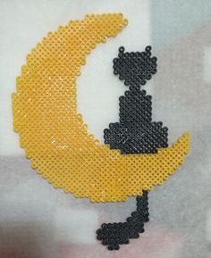 a yellow and black piece of art made to look like a moon with chess pieces on it