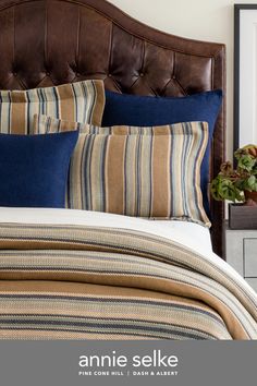 an image of a bed with blue and brown striped comforter set on top of it