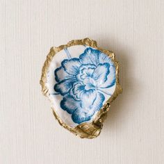 a blue and white flower on a gold plate