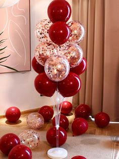 a bunch of balloons are on the floor in front of a table with red and white decorations