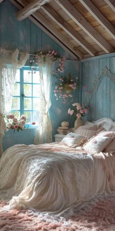 a bedroom with blue walls and white bedding, pink flowers on the window sill