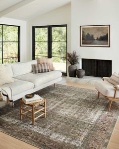 a living room filled with furniture next to a fire place and windows in the wall