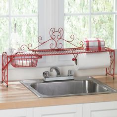 a kitchen sink under a window next to a towel rack