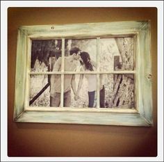 an old window frame with two people holding hands and looking at each other through it