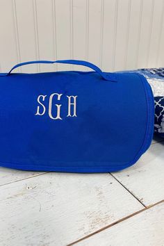 a blue personalized toiletry bag sitting on the floor