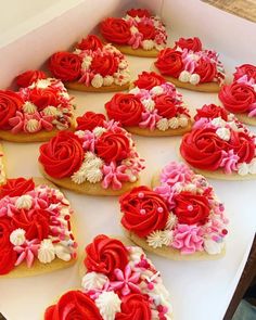 a box filled with lots of red and white decorated cookies on top of a table