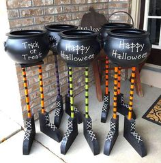 three halloween witch caulders sitting on the front porch