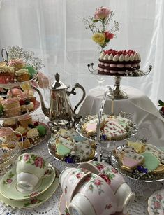 a table topped with plates and cups filled with cakes