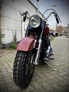 a red motorcycle parked next to a building