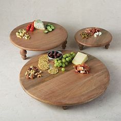 three wooden trays with different types of food on them