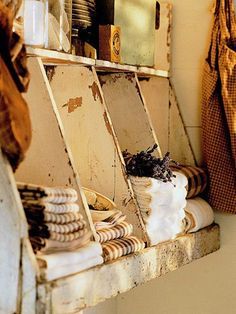 an old wooden shelf filled with dishes on top of a wall