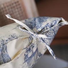 a blue and white pillow sitting on top of a chair