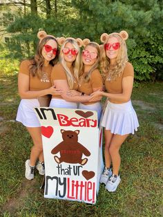 three girls in brown shirts and white skirts are holding a sign that says i'm bear