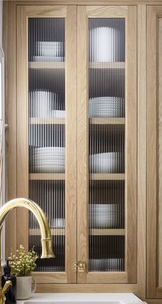 a wooden cabinet with glass doors in a kitchen