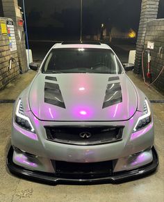 a silver sports car with purple lights on it