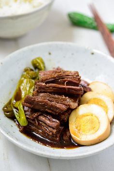 a white bowl filled with meat and vegetables