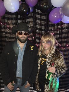 two people standing next to each other in front of balloons