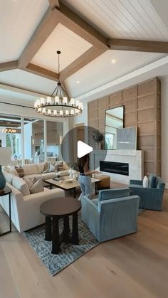 a living room filled with lots of furniture and a chandelier hanging from the ceiling