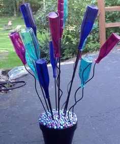 a vase filled with lots of different colored glass items on top of a black table