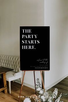 the party starts here sign on an easel in front of a couch with flowers