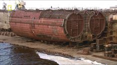 an old rusted boat sitting on top of a body of water next to a dock