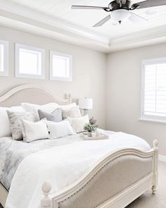 a white bed sitting in a bedroom next to a window