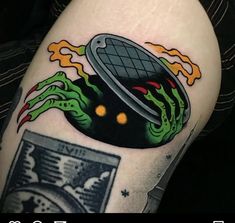 a person with a tattoo on their leg has an image of a black object in the background