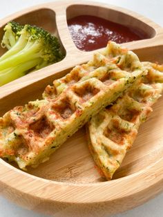 some waffles and broccoli on a wooden plate with ketchup