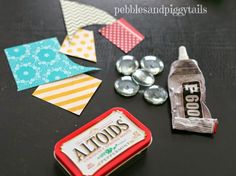 some candy tins are sitting on a table next to other candies and buttons