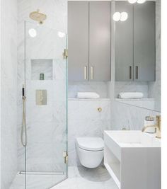 a white bathroom with marble walls and floor