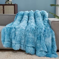 a fluffy blue blanket is sitting on a couch