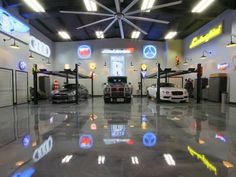 several cars are parked in a showroom with neon lights