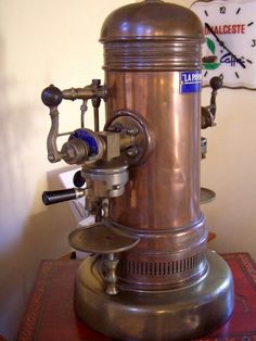 an old fashioned coffee grinder sitting on top of a table