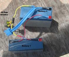 two batteries with wires connected to them on the ground next to each other and labeled battery 2