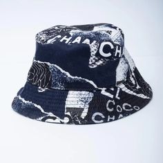 For Sale on 1stDibs - The hat is crafted of 100% cotton with camellia flowers and Chanel CC logos. COLOR: Navy / Black / White MATERIAL: Cotton CIRCUMFERENCE: 20” SIZE: S CONDITION: Luxury Summer Cap, Designer Adjustable Bucket Hat With Curved Brim, 1stdibs Fashion, Logos Color, Camellia Flowers, Summer Hats, White Material, Bucket Hat, Coco