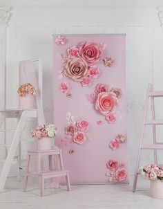 there is a pink wall with flowers on it and two ladders in the background