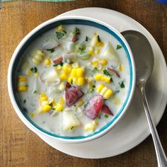 a bowl of corn and potato chowee with a spoon