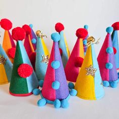 several colorful party hats with pom poms on them