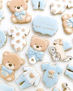 baby shower cookies with teddy bears and onesies on them, all decorated in pastel blue