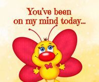 a yellow and red butterfly sitting on top of a wooden table next to a sign that says you've been on my mind today