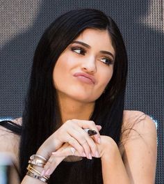 a woman with long black hair sitting down